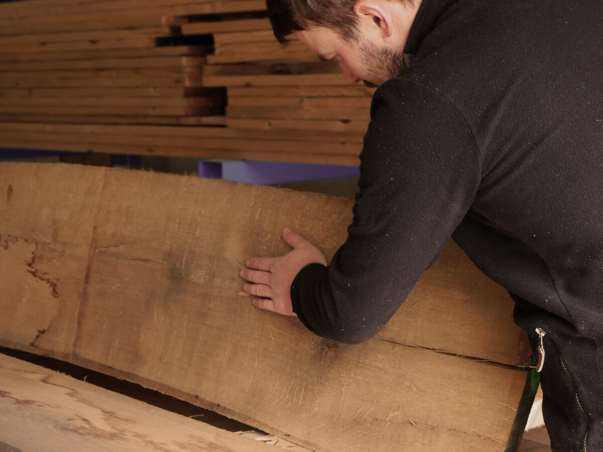 Benedikt Astner sucht ein geeignetes Holz in seiner Schreinerei in Oberaudorf